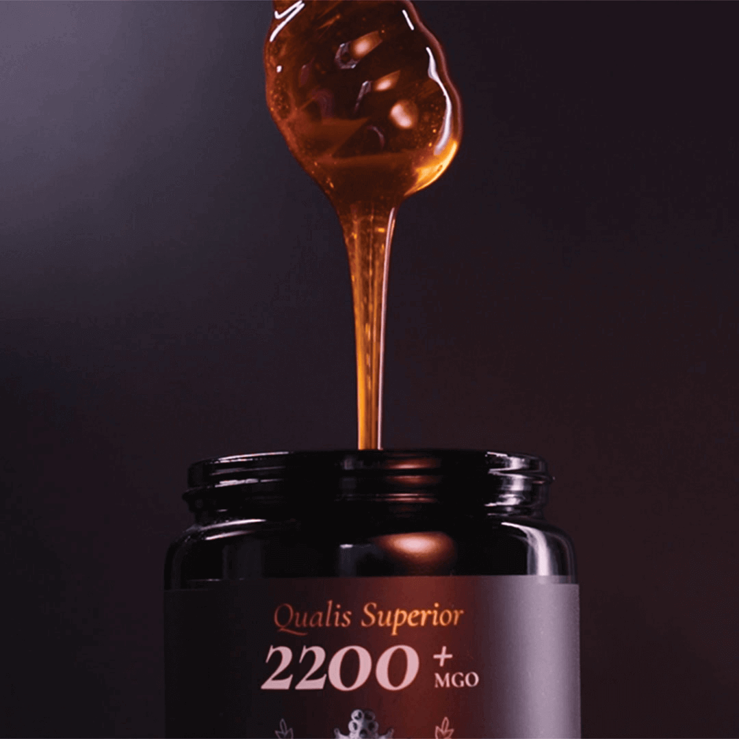 Manuka Honey being drizzled from a dipper into a Biosota jar MGO 2200